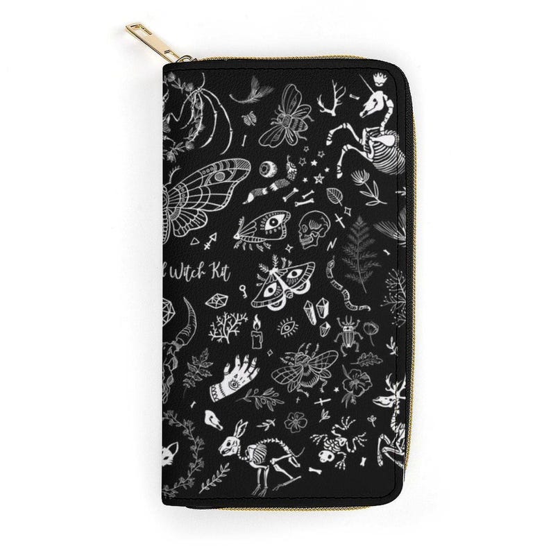 A flat view of the black zippered wallet adorned with white sketches of moths, bones, and hands.