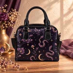 May include: A black handbag featuring a repeating pattern of purple flowers, winding snakes, golden crescent moons, mushrooms, and small stars. The bag has two black top handles, gold-toned hardware, and a structured rectangular shape.
