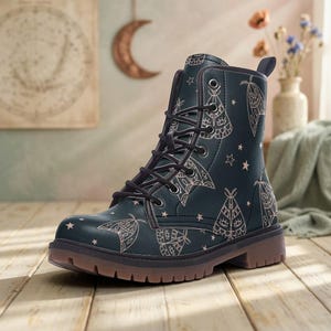 May include: A dark teal lace-up ankle boot featuring a repeating pattern of light-colored moths and small stars. The boot has a rounded toe, black laces, metal eyelets, a pull tab at the heel, and a thick, textured brown rubber sole.
