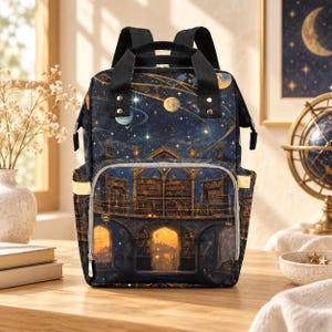 May include: A dark blue backpack featuring a celestial night sky print with planets and stars above a detailed illustration of a multi-story library with arched doorways, warm golden interior lighting, and black top handles and shoulder straps.