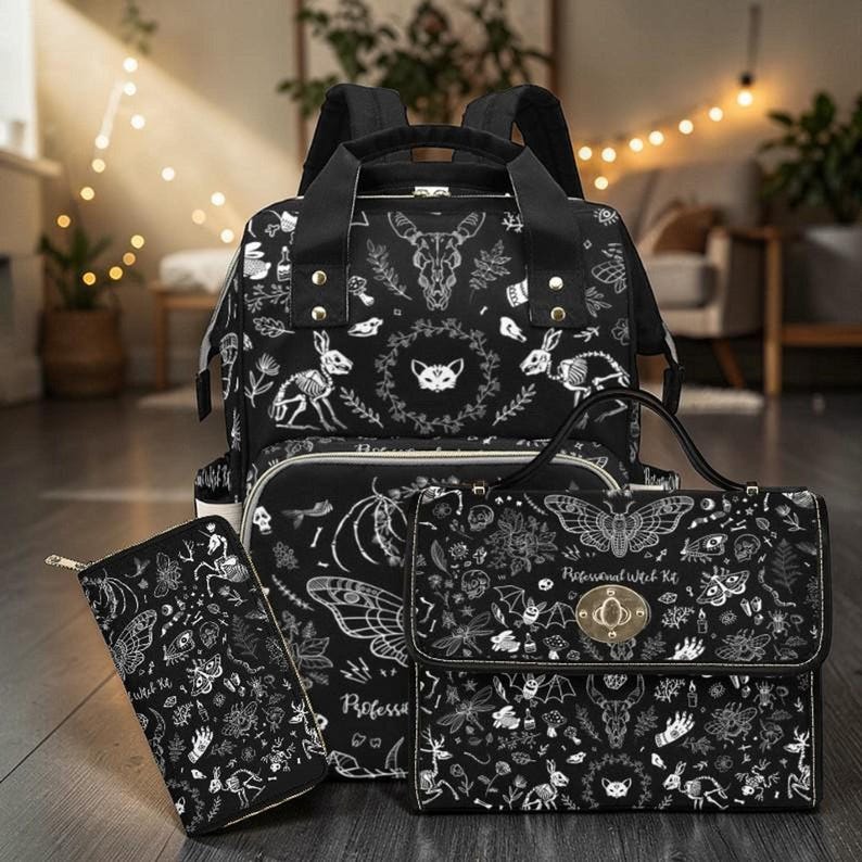 A matching set including the black backpack, a handbag, and a zippered wallet arranged on a floor.