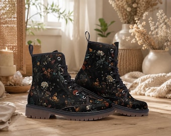 May include: Black combat boots with a floral design in orange, yellow, and white. The boots feature a lace-up closure and a dark brown sole. The boots are made of a soft, comfortable material. The boots are a stylish footwear option.