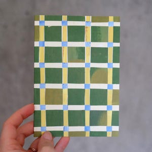 Könnte beinhalten: Eine rechteckige Karte mit einem Gittermuster aus dunkelgrünen Quadraten, die durch horizontale weiße und vertikale gelbe Linien getrennt sind, mit kleinen hellblauen Quadraten an den Schnittpunkten.