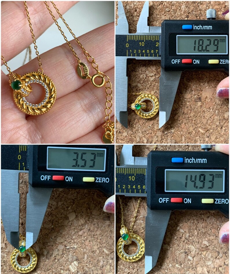 May include: A gold necklace with a pendant featuring a green stone and a circular design. The pendant measures 1.53 inches in diameter and the necklace is 18.29 inches long.