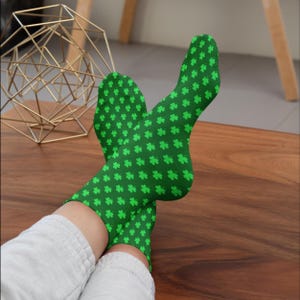 Puede incluir: Un par de calcetines verdes con un patrón de trébol. Los calcetines están hechos de un material suave y cómodo y son perfectos para el uso diario.