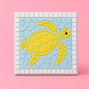 May include: A square tile featuring a mosaic-style design of a yellow sea turtle centered on a light blue background. The turtle is composed of segmented shapes, and the entire image is framed by a border of small, light pink square tiles.
