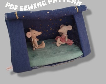May include: A blue and gold fabric tent with a star-patterned ceiling. Two small plush mice are sitting inside the tent. The tent is a sewing pattern.