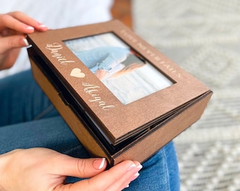 May include: A brown wooden photo box with a clear window to display a photo. The box has the words "Forever Falls" and "David & Abigail" engraved on the front.