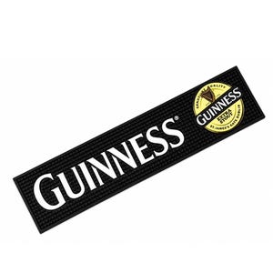 May include: A rectangular black rubber bar mat with a textured surface. The word GUINNESS is printed in large white capital letters. A circular gold and black logo features the text GUINNESS EXTRA STOUT ST. JAMES'S GATE DUBLIN and a harp.