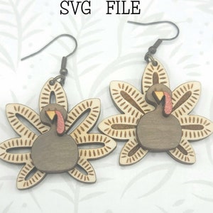 May include: A pair of wooden turkey earrings with a brown, white, and orange design. The earrings are shaped like a turkey with its tail feathers spread out. The text "Glowforge Ready SVG FILE" is visible in the image. "not a physical product" is also visible in the image.