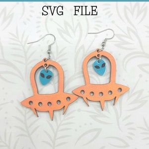 May include: A pair of orange and blue alien spaceship earrings. The earrings are made of wood and have a silver hook. The earrings are ready to be cut on a Glowforge.