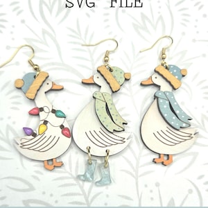 May include: Wooden earrings featuring goose designs with winter hats and scarves. One goose has a string of colorful lights. The text "Glowforge Ready" and "SVG FILE" are visible. The earrings are not a physical product.