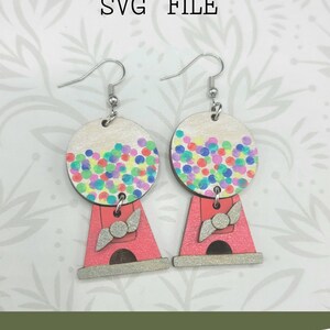 May include: A pair of gumball machine earrings with a pink base and a white gumball sphere filled with colorful gumballs. The earrings are made of wood and have silver hooks. Glowforge Ready SVG FILE. Not a physical product.