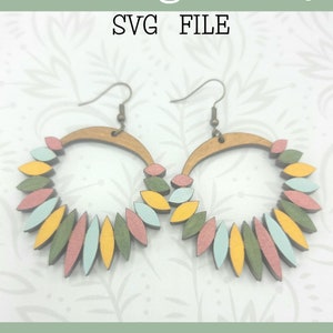 May include: A pair of wooden hoop earrings with a layered design of pink, yellow, and green ovals. The earrings are ready to be cut on a Glowforge. "Glowforge Ready SVG FILE" is written on the image. "not a physical product" is written at the bottom of the image.