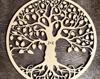 May include: A wooden tree of life wall decor with intricate carvings. The tree has a thick trunk and branches with leaves. The initials "J+K" are carved into the trunk, and the date "21-06-2014" is carved at the bottom.