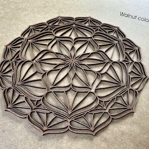 Op de afbeelding: Een walnootkleurig houten mandala met een ingewikkeld geometrisch ontwerp. De mandala is rond en heeft een centraal bloemvormig patroon.
