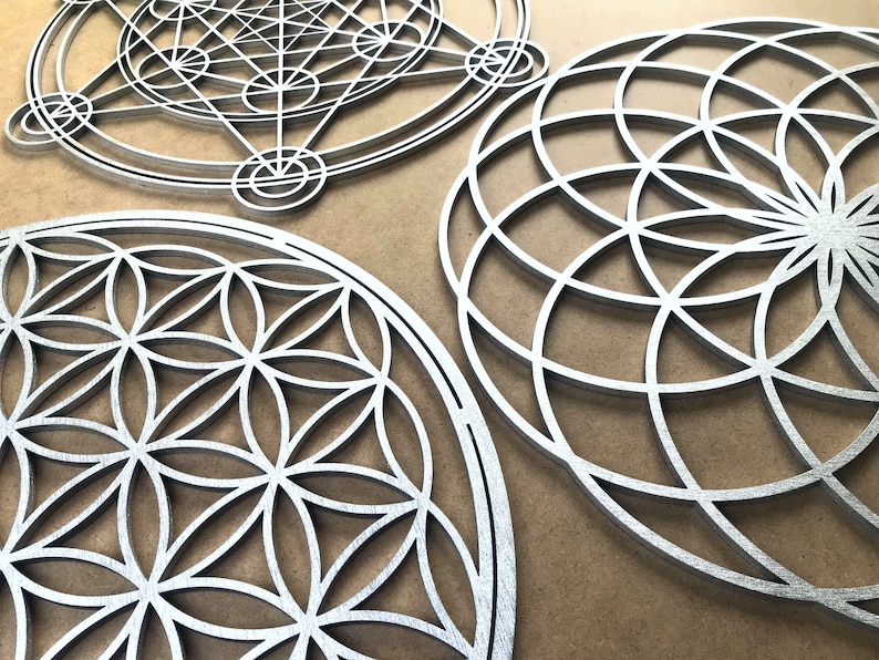 May include: Three silver metal wall decor pieces with geometric designs. The designs are intricate and detailed, and the pieces are all circular in shape.