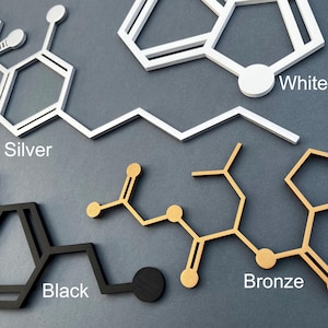 K&ouml;nnte beinhalten: Vier Wanddekorationen in Form von Molek&uuml;lstrukturen in verschiedenen Farben: Silber, Schwarz, Bronze und Wei&szlig;. Die Strukturen sind aus Holz gefertigt und haben einen 3D-Effekt.