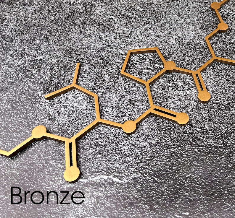 K&ouml;nnte beinhalten: Eine goldfarbene Metall-Molek&uuml;lstruktur auf einem grauen, strukturierten Hintergrund. Das Wort "Bronze" steht unter der Struktur.