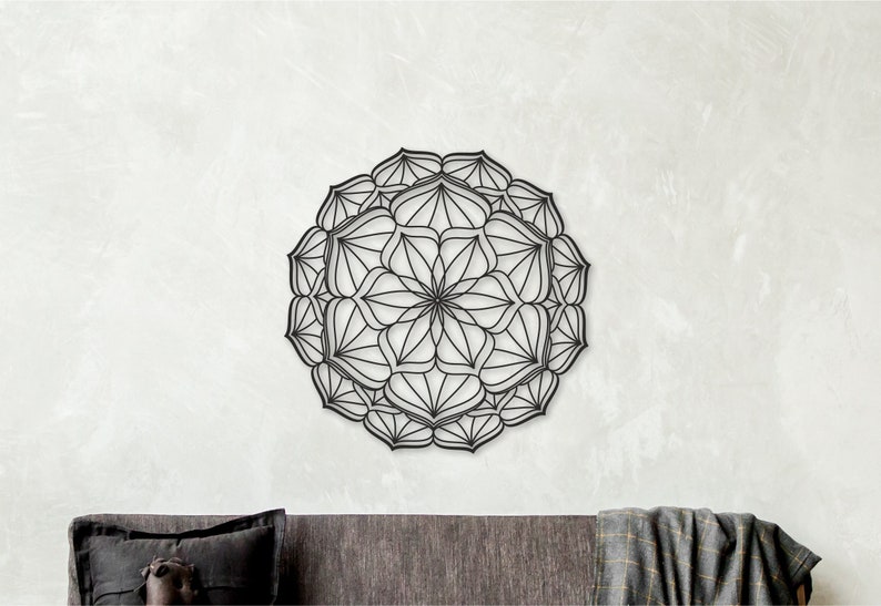 Op de afbeelding: Zwarte metalen mandala wanddecoratie met ingewikkelde geometrische patronen. De mandala is rond en heeft een symmetrisch ontwerp.