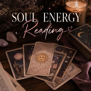 May include: A set of tarot cards featuring celestial illustrations of the sun, moon, and stars, with the text SOUL ENERGY Reading displayed in white and rose gold script. A lit candle and smooth stones are positioned near the deck of cards.
