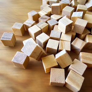 May include: A pile of natural wood blocks, scattered on a wooden surface. The blocks are various sizes and shapes, with some stacked on top of each other.