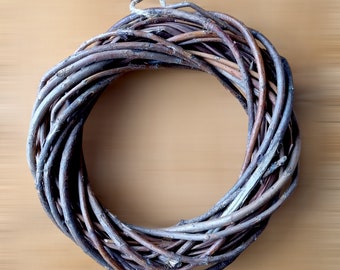 May include: A brown twig wreath with a natural twine hanger. The wreath is made of woven twigs and is perfect for decorating a door or wall.