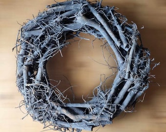 May include: A gray twig wreath made of natural branches, perfect for a rustic or farmhouse decor theme.