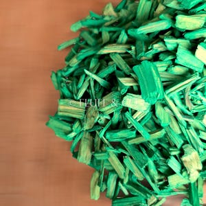 Puede incluir: Virutas de madera verdes para paisajismo o jardinería. Las virutas están hechas de madera natural y están teñidas de verde.