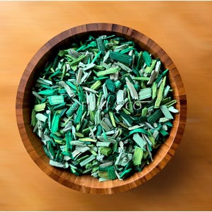 May include: A wooden bowl filled with green and light green wood shavings.