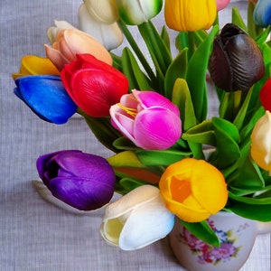 Peut inclure: Un bouquet de tulipes color&eacute;es dans un vase &agrave; motif floral. Les tulipes sont dans des tons de bleu, violet, rose, rouge, jaune, blanc et noir.