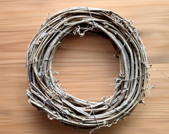 May include: A natural twig wreath, woven into a circular shape, with a rustic brown color. The wreath is made of thin, dried twigs, and is held together with wire.