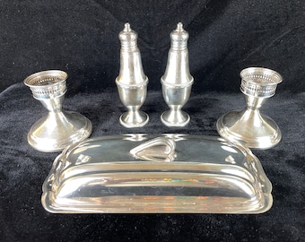 May include: A silver butter dish with a heart-shaped handle, two silver salt and pepper shakers, and two silver candle holders.
