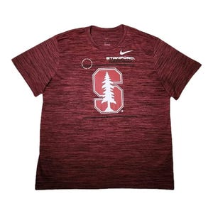 Puede incluir: Camiseta deportiva granate con cuello redondo y mangas cortas. La camiseta presenta el logo de Nike y la palabra "STANFORD." encima de un gr&aacute;fico blanco de la letra "S" con un &aacute;rbol en su interior. La tela tiene un patr&oacute;n texturizado.