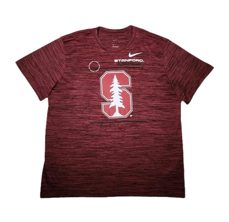 Puede incluir: Camiseta deportiva granate con cuello redondo y mangas cortas. La camiseta presenta el logo de Nike y la palabra "STANFORD." encima de un gr&aacute;fico blanco de la letra "S" con un &aacute;rbol en su interior. La tela tiene un patr&oacute;n texturizado.