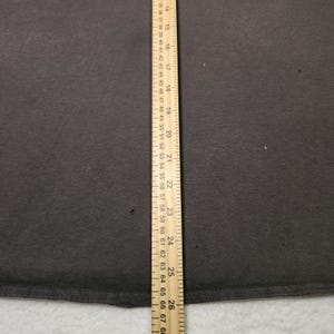 Puede incluir: Una tela gris oscuro con una regla de madera colocada verticalmente en el lado izquierdo. La regla mide hasta 66 cm, con marcas para cada cm e incrementos m&aacute;s peque&ntilde;os. La tela parece ser de color s&oacute;lido.