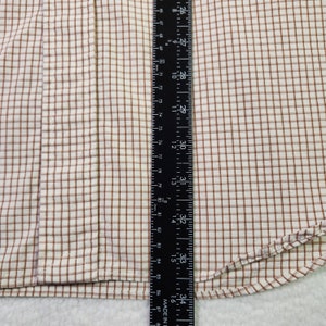 May include: A white and brown plaid fabric with a brown seam along the edge. A black ruler is placed along the bottom edge of the fabric. The ruler is marked in inches and centimeters.