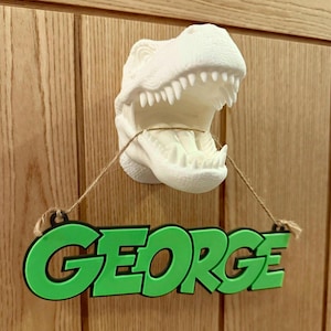 May include: A white dinosaur head wall mount with a green nameplate that says "GEORGE" hanging from its mouth.