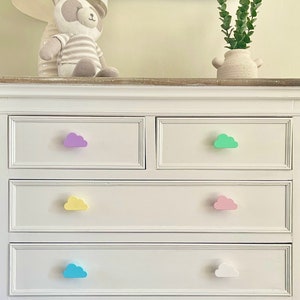 May include: White chest of drawers with five drawers and cloud-shaped drawer pulls in various pastel colours: purple, yellow, pink, blue, and white.