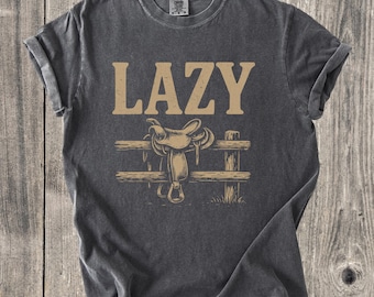 Camiseta Lazy Cowboy Saddle, camiseta gráfica vintage del Oeste, colores rústicos y cómodos para rancho, camiseta vaquera de rodeo, camiseta unisex del Oeste campestre.