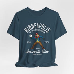 May include: A navy blue t-shirt featuring a graphic for the Minneapolis Snowballs Club. The design includes a cartoon figure throwing a snowball, the text "Minneapolis", and the phrase "Only You Can Prevent Fascism."