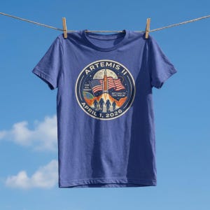 May include: A white ceramic mug with a black handle and the text "But First, Coffee" in a bold, black font. The mug is set against a blurred background, suggesting a cozy setting.