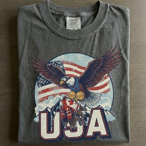 Funny USA Ice Hockey Eagle, USA Champions 2026 Shirt, USA Hockey Shirt 2026, Patriotic Ice Hockey Tee, Funny Sports Unisex T-shirt Pepper