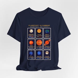 May include: A navy blue t-shirt featuring a graphic of the planetary alignment on 25 January 2025. The graphic depicts the planets Mercury, Venus, Earth, Mars, Jupiter, Saturn, Uranus, Neptune, and Pluto.