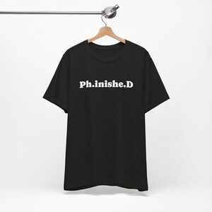 Puede incluir: Camiseta negra con texto blanco que dice "Ph.inishe.D"