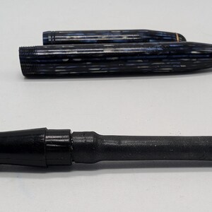 May include: Two blue and white striped fountain pens and a black fountain pen nib.