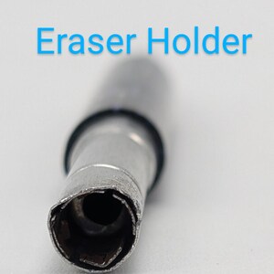 May include: Close-up of a silver metal eraser holder with a black rubber ring. The holder has a circular opening with a serrated edge.