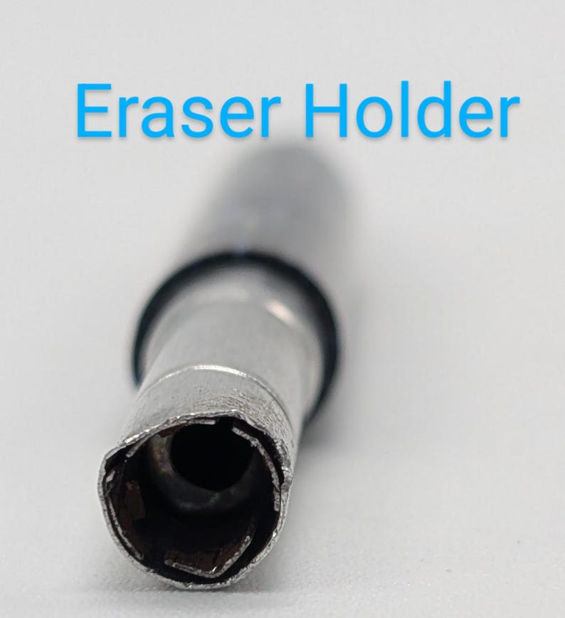 May include: Close-up of a silver metal eraser holder with a black rubber ring. The holder has a circular opening with a serrated edge.