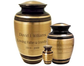 May include: Three gold and black striped cremation urns with engraved names and dates. The largest urn has the inscription "David J. Williams Loving Father & Grandp 1919-2006". The middle urn has the inscription "David J. Williams Forever In Our Hearts 1919-2006". The smallest urn has the inscription "David J. Williams Loving Father 1919-2006".
