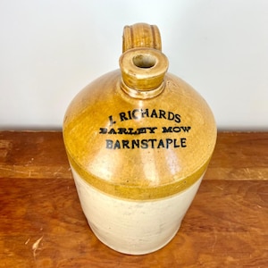 May include: A brown and white ceramic jug with a handle. The jug has black lettering that reads "J. Richards Barley Mow Barnstaple".